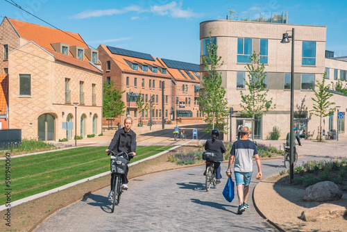 Vászonkép Beautiful girl riding a bike on a new bike path or road between modern buildings