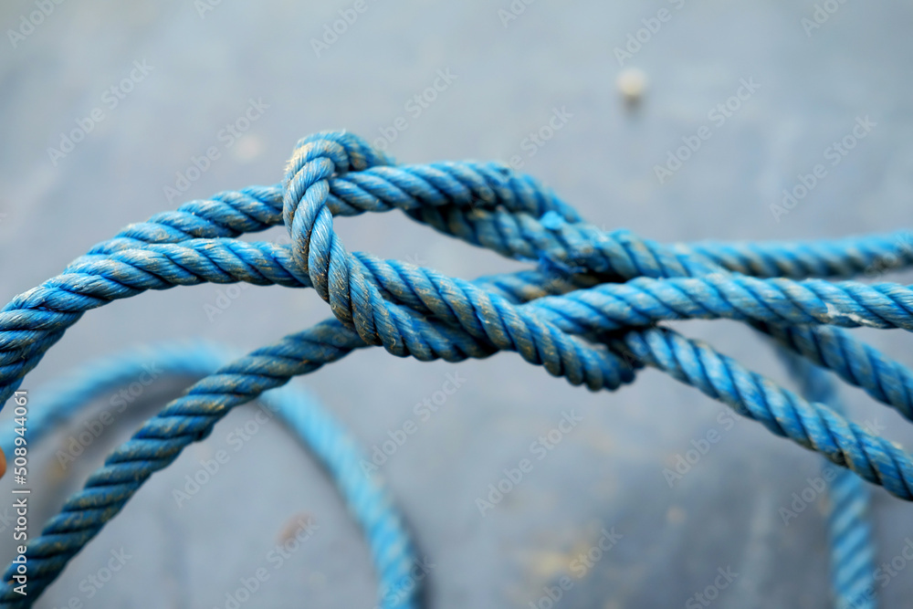 Rope with knots on grey background