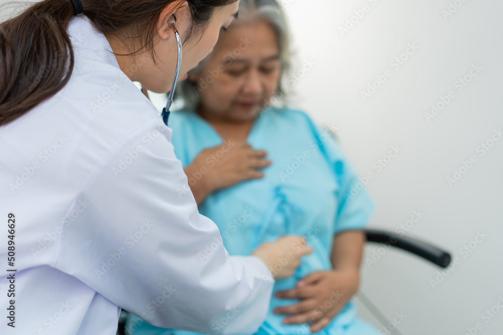 Physician examining heart with a stethoscope and talking with a senior woman at a clinic for check yearly checkup, Medicine health care service and medical insurance concept. Physician examining heart with a stethoscope and talking with a senior woman at a clinic for check yearly checkup, Medicine health care service and medical insurance concept.