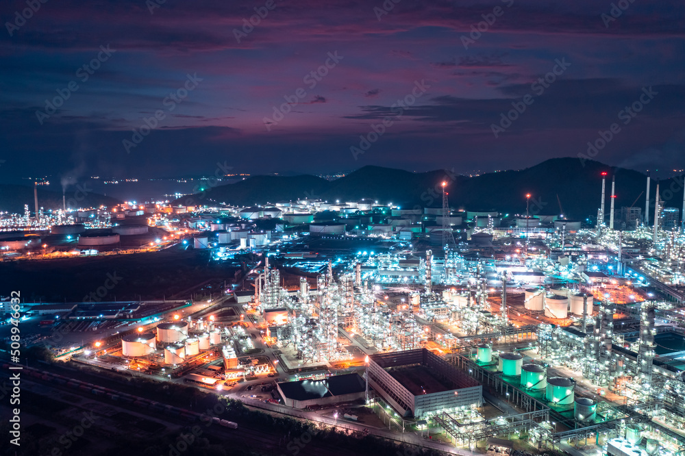 Aerial view of factory zone Oil and gas industry - refinery stores tank and Petrochemical plant on island at twilight over lighting