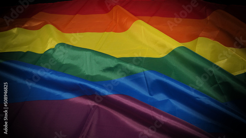 LGBTQ pride flag on black background. Lgbt rainbow flag in gay hand. Represent symbol of freedom peace equality and love and respect diversity of sexuality. Lesbian Gay Bi sexsual Transgender Queer.