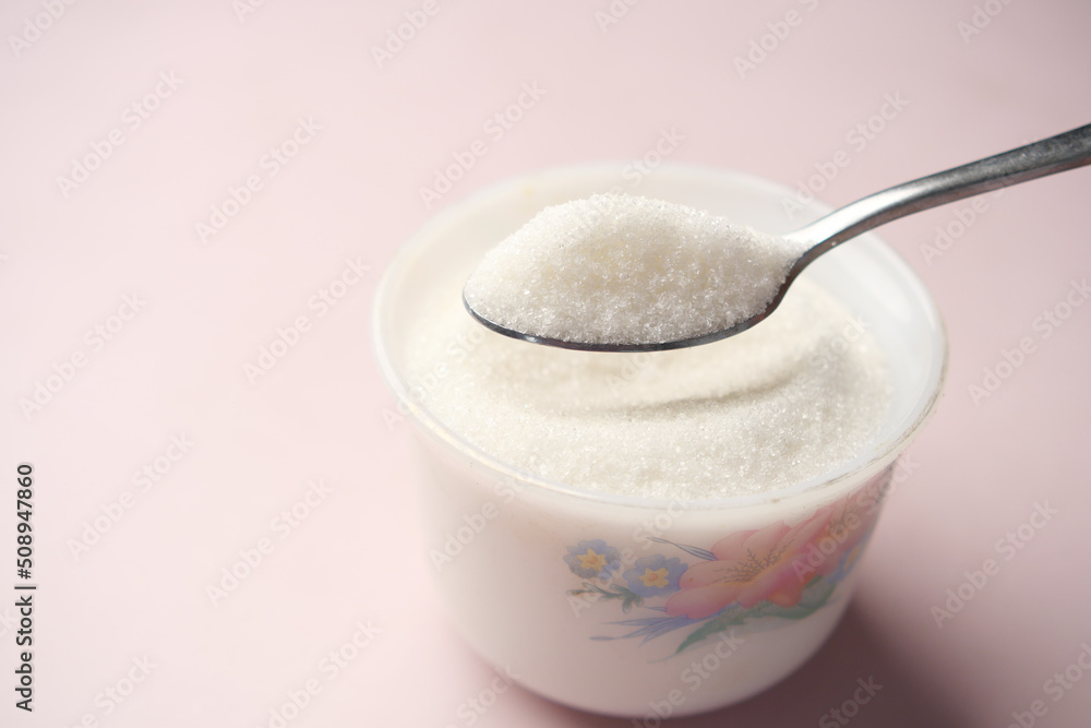 white sugar and spoon in a container on black background, white sugar and spoon in a container on black background,