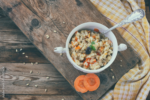 Pearl barley porridge with carrots, onions in white bowl