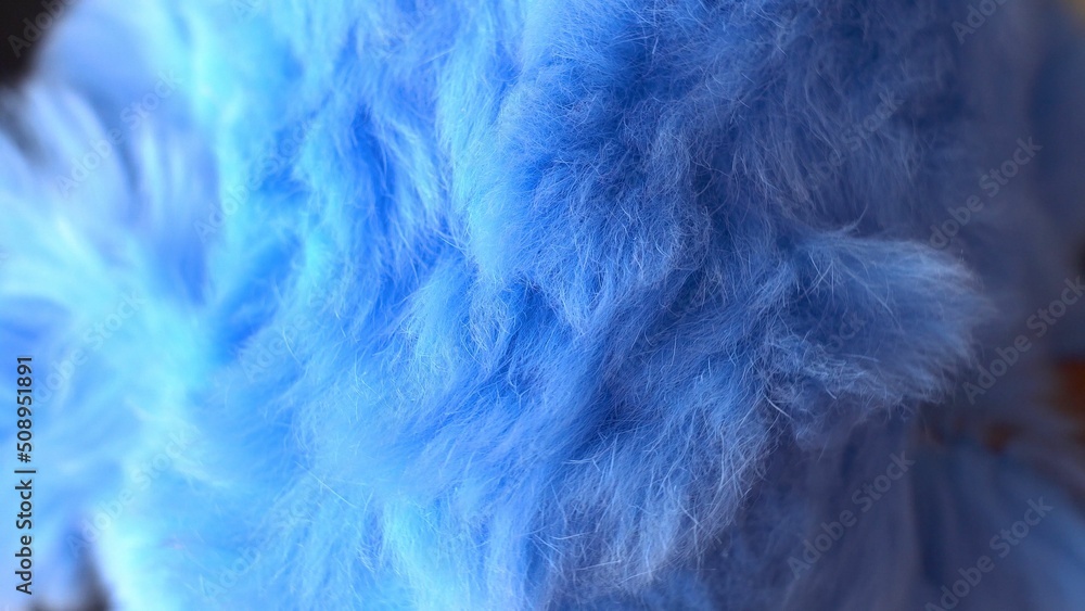 Obraz premium Blue faux fur. long pile. Children's toy. Piece of clothing. animal protection. Substitute for natural fur. fabric production. close-up.