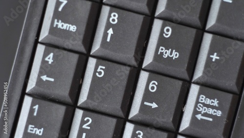 Black keyboard with numbers. White arrows and numbers. mini keyboard. gadget. calculator. computer device. close-up. macro photography.