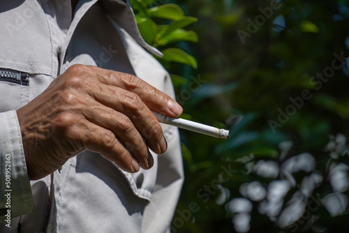 A man smoking a cigarette between work. 作業の合間にタバコを吸う男性 © Kana Design Image