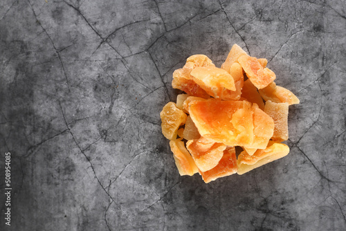 a pile of candied cantaloup  rock melon  isolated on gray background flat lay. Image contains copy space