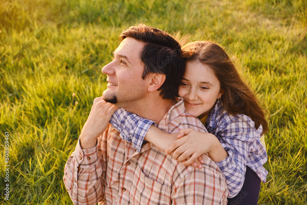 Smiling little girl hugging her father outside