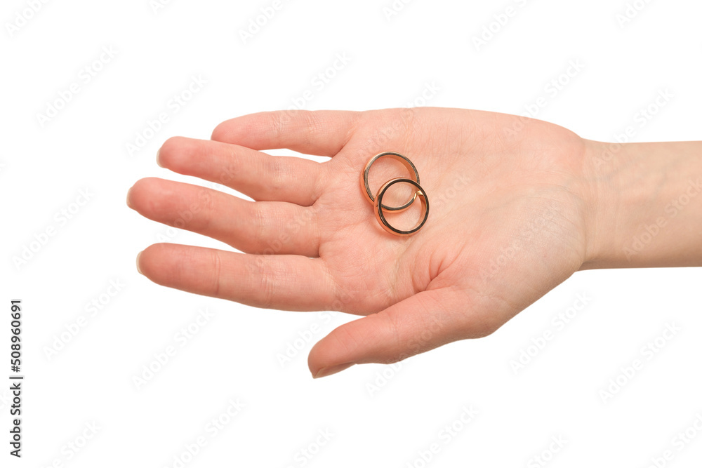 Two golden rings in a woman hand isolated on a white background.