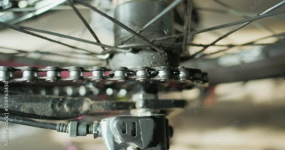 bicycle chain rotates the rear wheel of the bicycle, the sprocket is spinning, closeup. Top