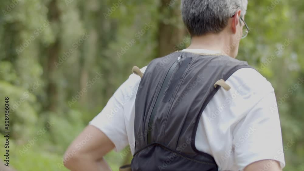 Man in eyeglasses running on trail in forest. Close-up shot of man in T-shirt jogging in nature, doing cardio workout alone. Trail running, healthy lifestyle, fitness concept Man in eyeglasses running on trail in forest. Close-up shot of man in T-shirt jogging in nature, doing cardio workout alone. Trail running, healthy lifestyle, fitness concept