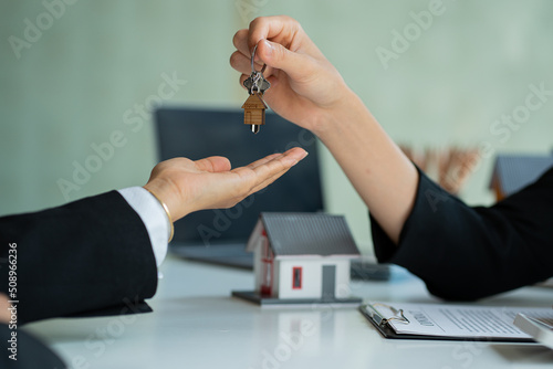 The salesperson delivers the house keys to the customer, from the sale of the house, and samples with the home purchase contract to the customer who purchases the house. with real estate insurance