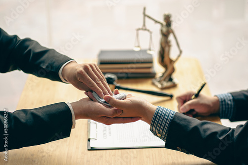 Obraz na płótnie When a court or lawyer receives money from a businessman in exchange for a grant Making an unjust judgment is a corruption and taking a bribe at a table with a hammer and a god of justice beside it