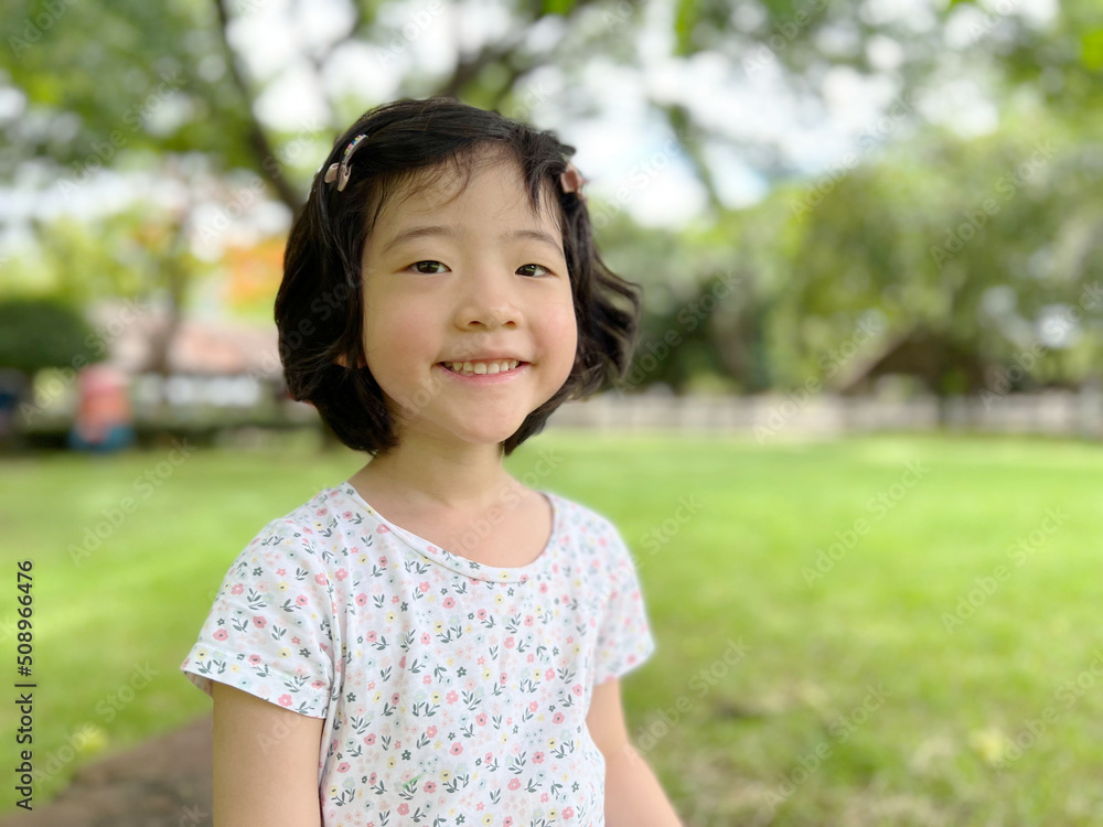 cute little girl smiles in the garden with copy space cute little girl smiles in the garden with copy space