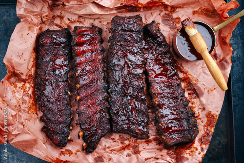 Barbecue pork spare loin ribs St Louis cut with hot honey chili marinade served as top view on a butcher paper photo