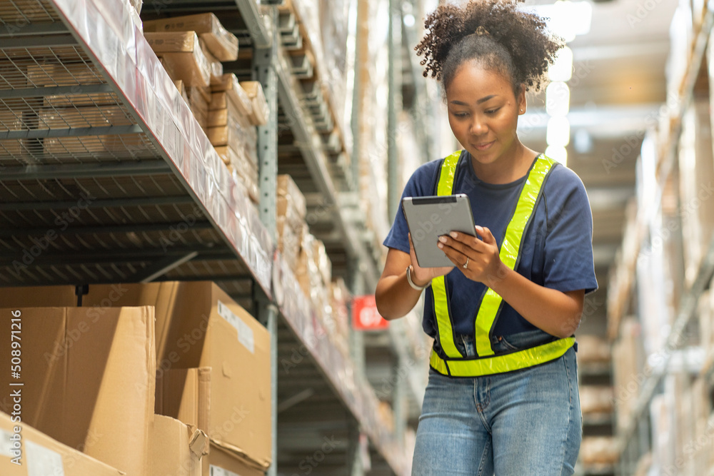African American female worker holding a tablet to count merchandise at a wholesale store African American female worker holding a tablet to count merchandise at a wholesale store