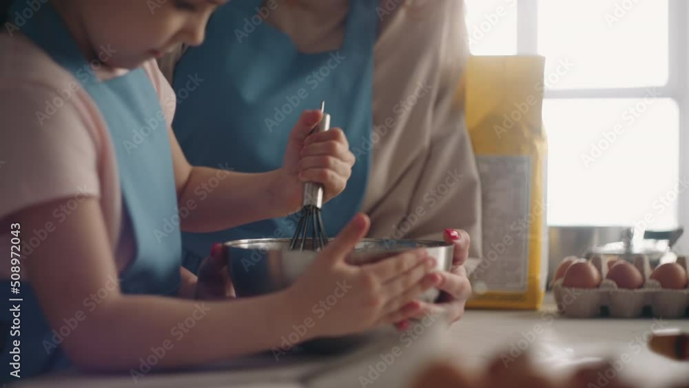 calm family weekend in home, mom and daughter are cooking together, little girl is whipping cream calm family weekend in home, mom and daughter are cooking together, little girl is whipping cream