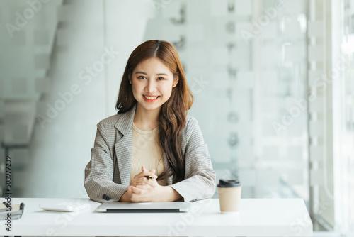 Young beautiful woman using her laptop while sitting in a chair at her working place,  Small business owner people employee freelance online sme marketing e-commerce telemarketing concept.