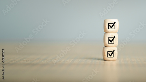 Checklist, Corporate regulatory and compliance, approve, Quality control management, ISO certification, service quality warranty concept. Check mark icon on wooden cube blocks with copy space.