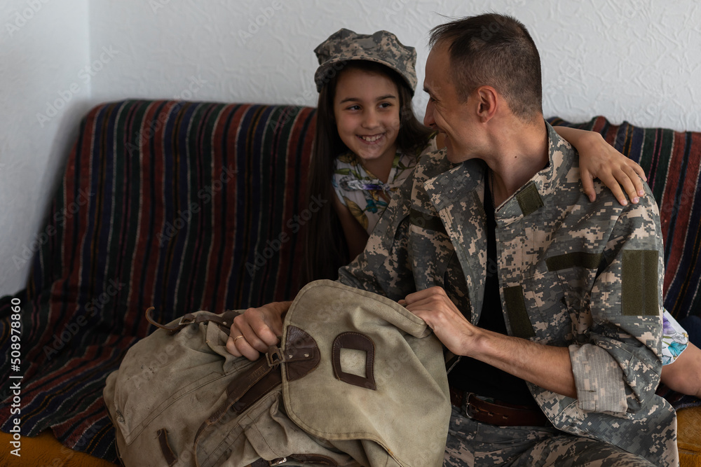 Affectionate military father with daughter at home.