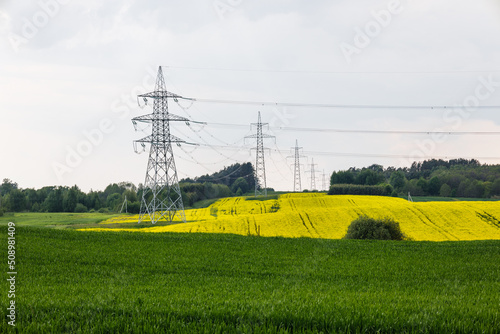 High voltage electricity poles and transmission power lines in the agricultural field