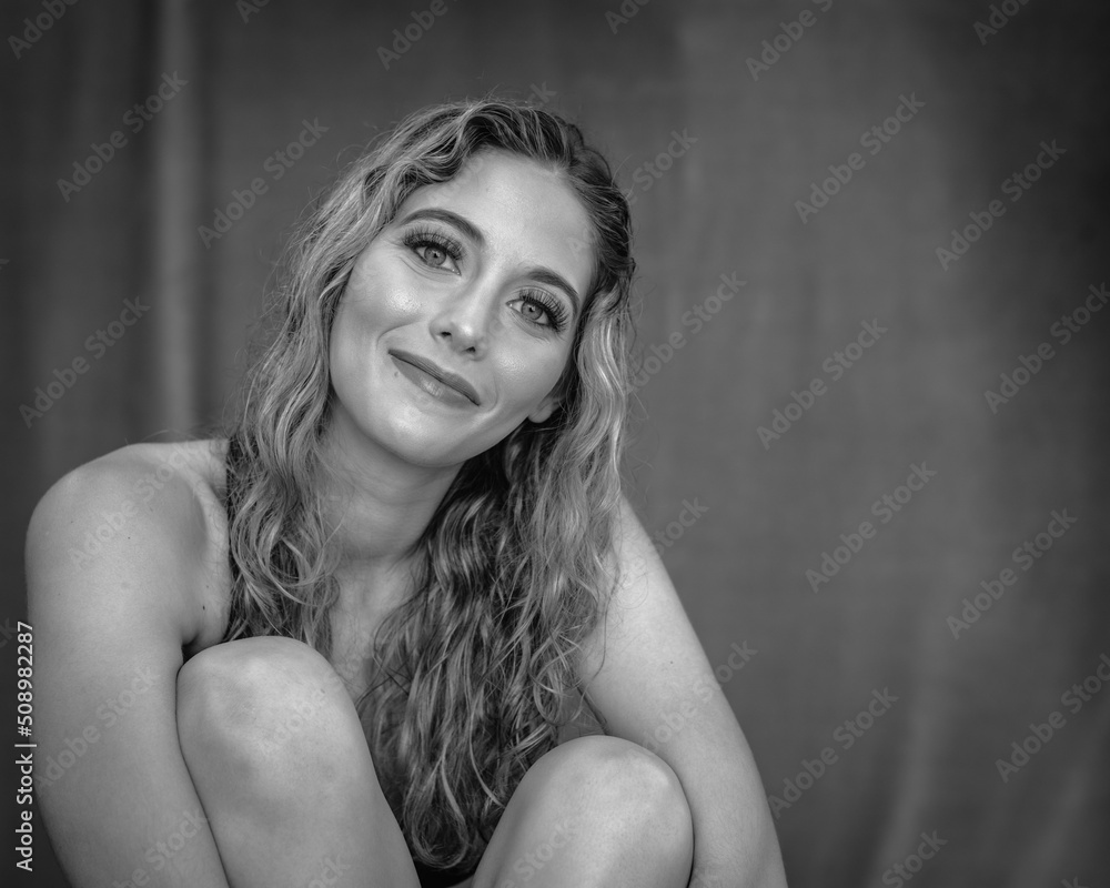 Athletic young woman sits for a photo session between sets at the gym. Athletic young woman sits for a photo session between sets at the gym.