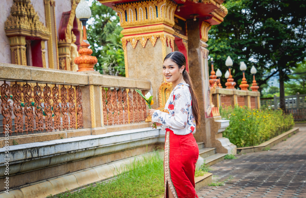 Fototapeta premium Beautiful Asian girl at big Buddhist temple dressed in traditional costume