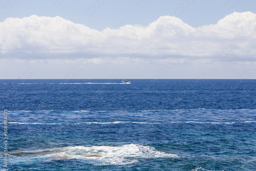 Lone white motor yacht crosses bay leaving white foam trail behind it, Ibiza, Balearic Islands, Spain Lone white motor yacht crosses bay leaving white foam trail behind it, Ibiza, Balearic Islands, Spain
