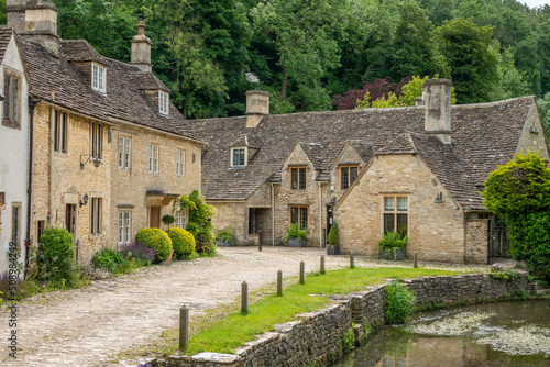 honey coloured Cotswold stone houses and Bybrook river in Castle Combe Wiltshire England often named as the prettiest village in England photo