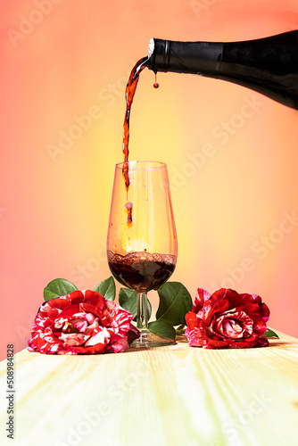 vertiendo vino tinto en una copa, atardeciendo, bodegón con rosas y tonos cálidos la rioja, España