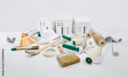 house painter tools, brushes, paint rollers, paper masking tape and colors swatches on blueprint with model house, supply and service in color shop in the hardware and store of building material.