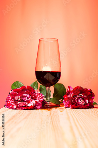 vertiendo vino tinto en una copa, atardeciendo, bodegón con rosas y tonos cálidos la rioja, España photo