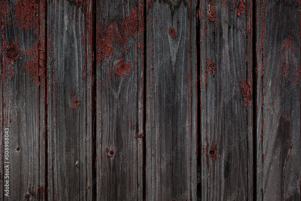 Fototapeta premium Old natural weathered wooden planks with cracked red paint background