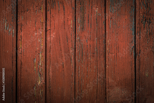 Old natural weathered wooden planks with cracked red paint background