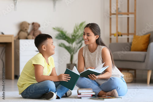 Little Asian boy reading bo...