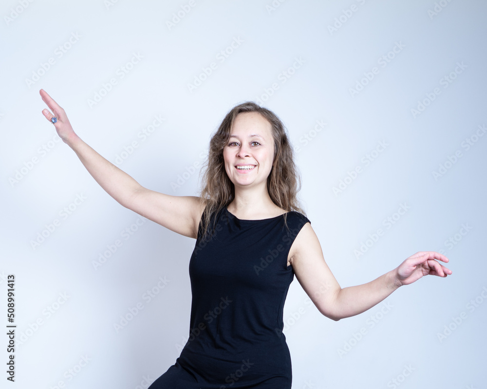 girl in a black dress and with natural make-up keeps balance and smiling girl in a black dress and with natural make-up keeps balance and smiling
