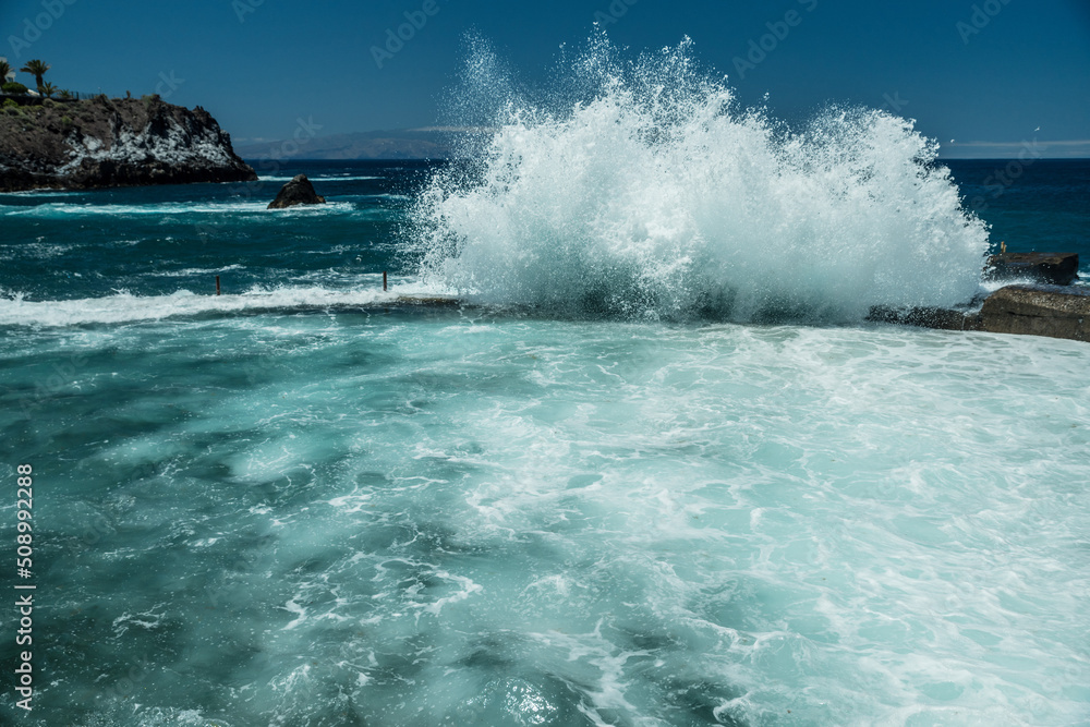 Rocky coastline and big wave breaking on natural swimming pool of Tenerife Island.