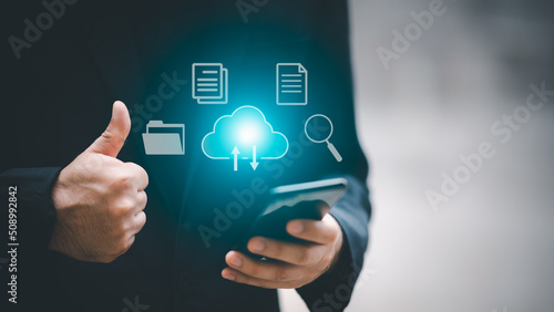 A man uses a smartphone to access an online document database. and automated processes to store files and documents in the organization effectively with enterprise business ERP technology