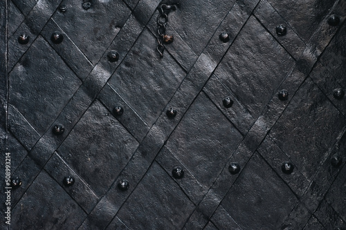 Old forged black metal door with stripes and rivets of the Boim chapel in Lviv, Ukraine. Vintage background closeup.