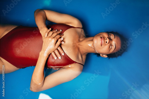 Canvastavla Beautiful middle-aged African American woman floating in tank filled with dense salt water used in meditation, therapy and alternative medicine