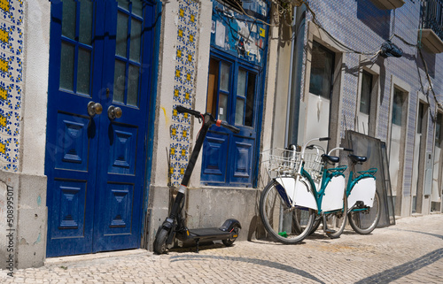 Typical portugal street in Aveiro old town. House with blue colored doors and renter bikes and scooter © BooFamily