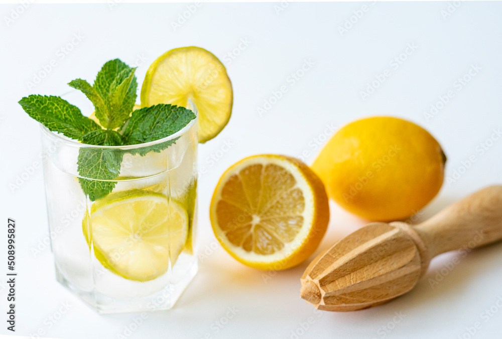 Healthy food, drinks, diet. Close-up of a glass with water, lemon and mint on a white background. Healthy food, drinks, diet. Close-up of a glass with water, lemon and mint on a white background.