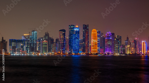 view of doha corniche during night along with fanar building.