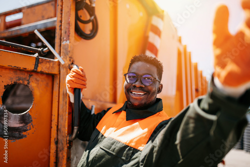 Portrait of a African American worker of the city utility company. Garbage collector.