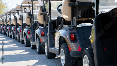 Fotografija A row of electric golf carts on a golf course.