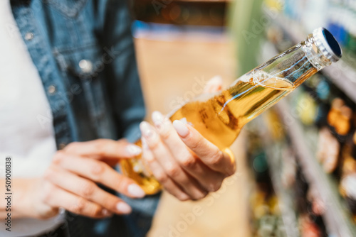 Close-up beer bottle in young woman hands