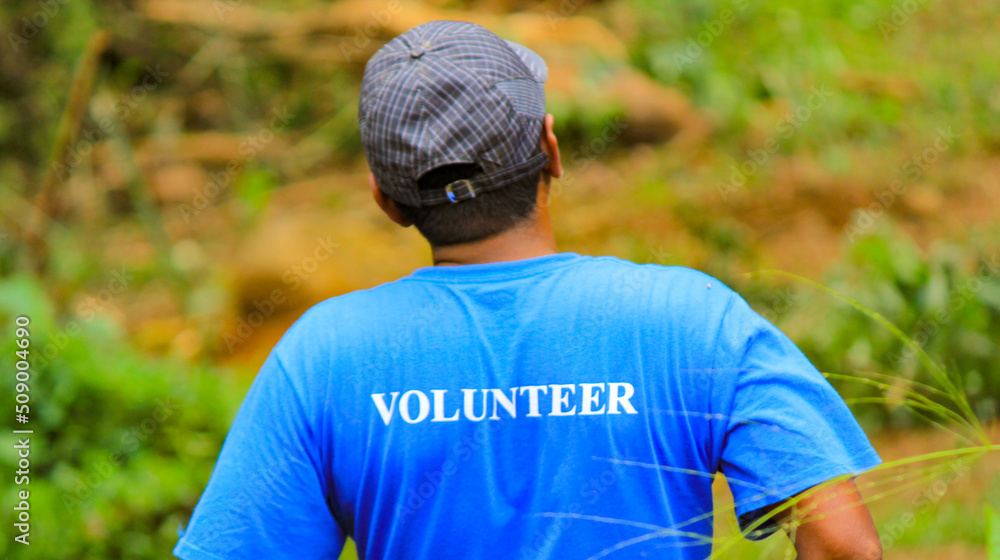 Naklejka premium A guy wearing volunteer tshirt during volunteering activity.