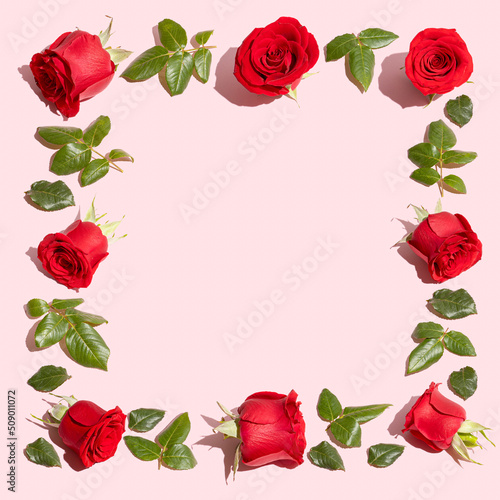 Creative flowers composition. Vintage frame made of red roses on pastel pink background. Minimal flat lay. Valentine s Day or love concept.