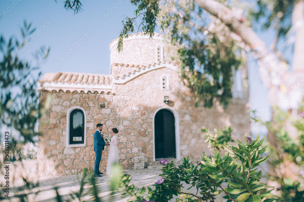 Wedding in Cyprus. A couple of newlyweds are photographed near the walls of the Temple of Elijah the Prophet in Protaras.