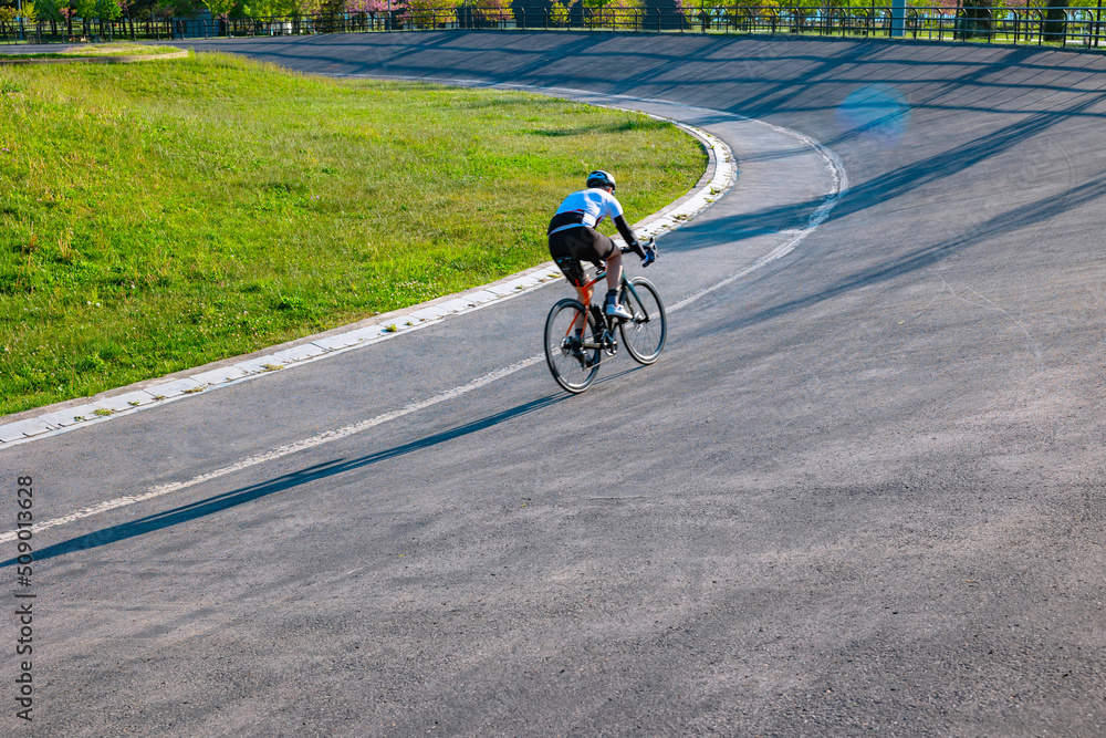Obraz premium Cyclist training on the cycle-racing track in the park. Biker or bicycle sport